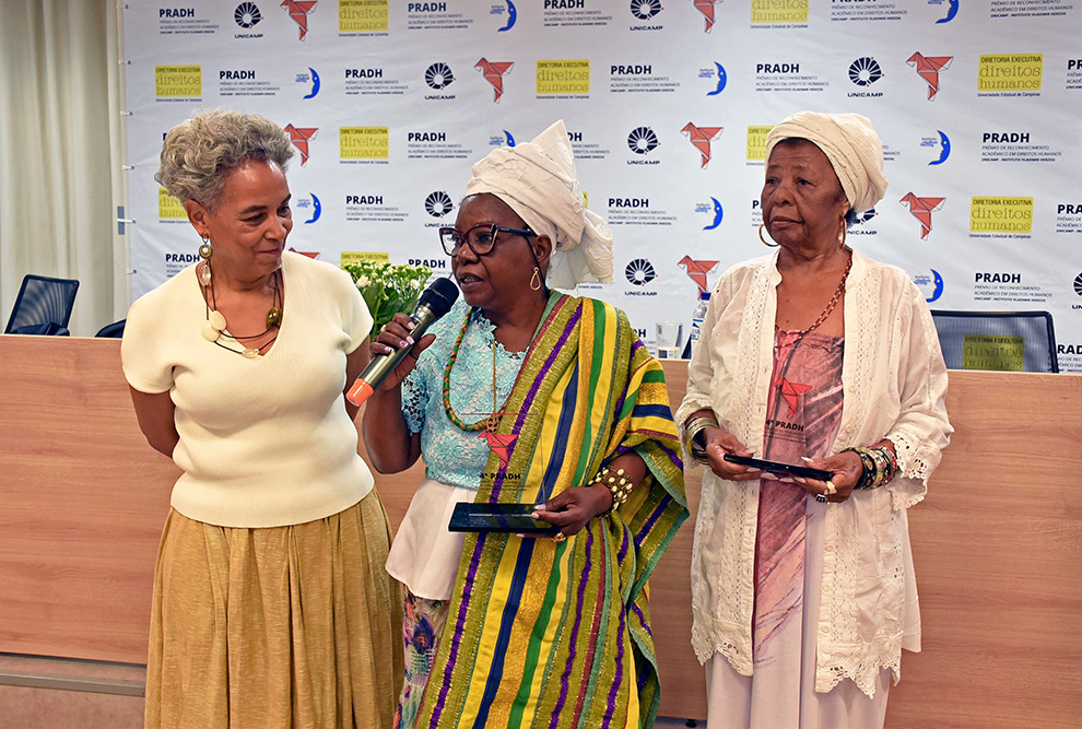Da esquerda para a direita, a diretora executiva de Direitos Humanos, silvia Santiago e as lideranças tradicionais de matriz africanas homenageadas, Mãe Dango e de Mãe Corajacy