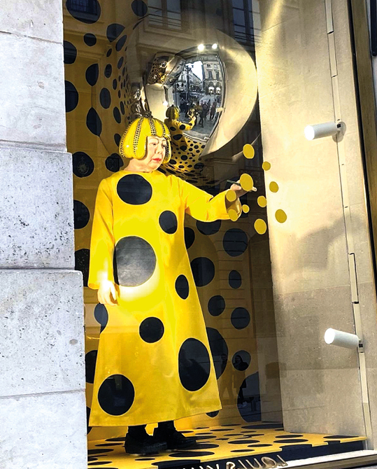 Representação da artista contemporânea japonesa Yayoi Kusama em vitrine de loja parisiense da Louis Vuitton