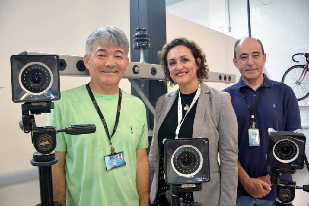 Da esq. para a dir.: Prof. Milton Misuta, Profa. Sandra Gemma e Prof. José Brittes no Laboratório de Instrumentação Biomecânica (LABIN) da FCA Unicamp, com uma cruzeta (simulando um poste de força) e as câmeras do sistema optitrack, equipamentos utilizados na pesquisa. Foto: Cristiane Kämpf – Comunicação FCA Unicamp.