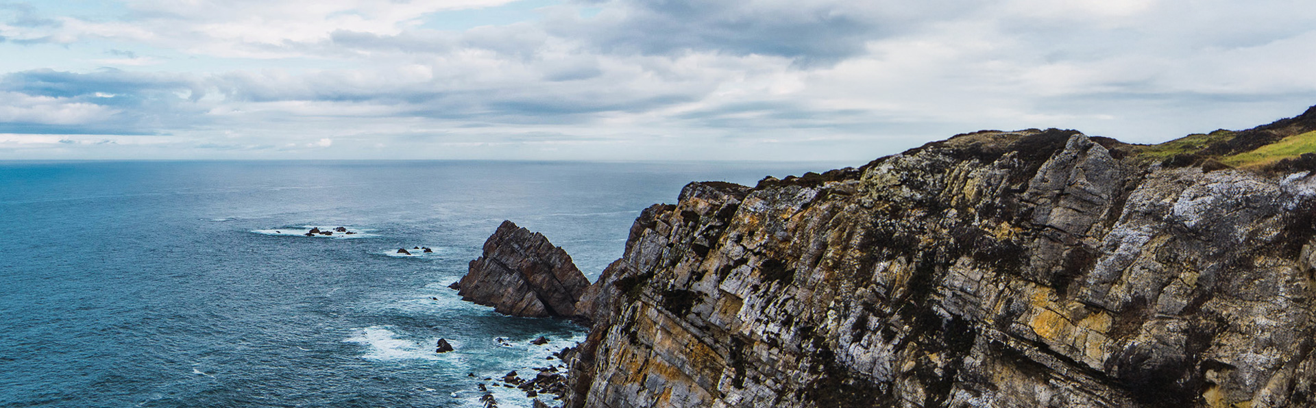 foto-de-alto-angulo-mar-perto-da-montanha-sob-um-ceu-nublado-em-cabo-penas-asturias-espanha-DESKTOP