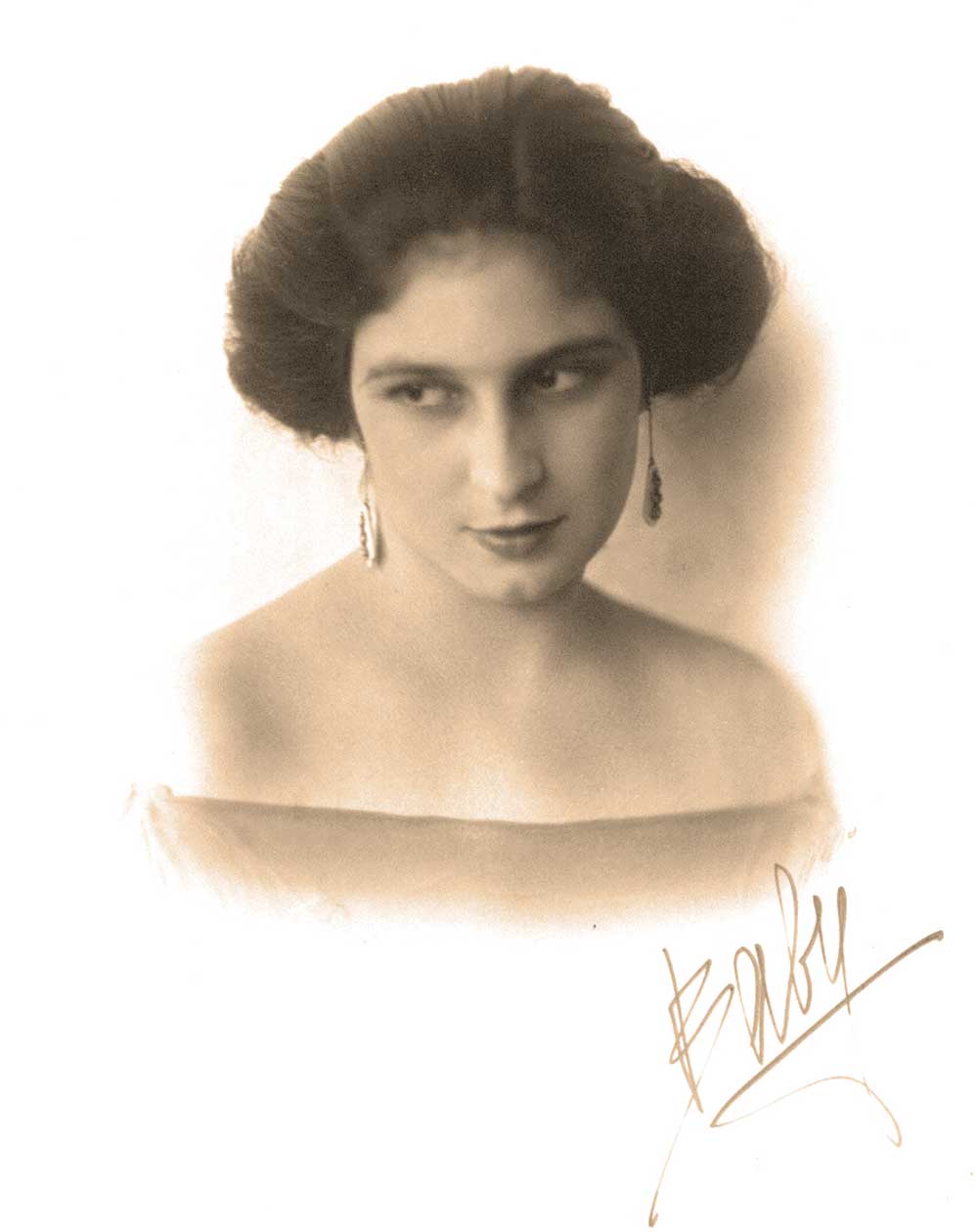A imagem apresenta uma mulher em um retrato de estilo vintage, com tonalidade sépia que remete a fotografias do início do século XX. Ela está posicionada de frente, mas seu olhar está levemente direcionado para o lado, transmitindo uma expressão serena e introspectiva.