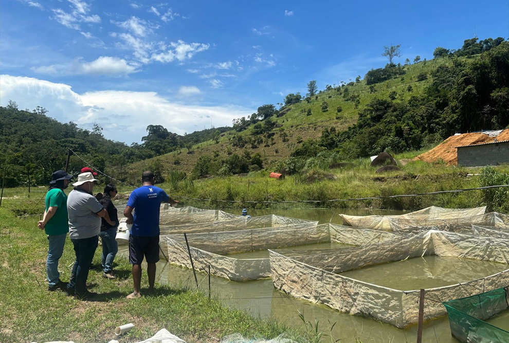 DAT de Jacupiranga (SP); o produtor rural (de azul) mostrando como funciona o processo de criação de tilápias aos pesquisadores