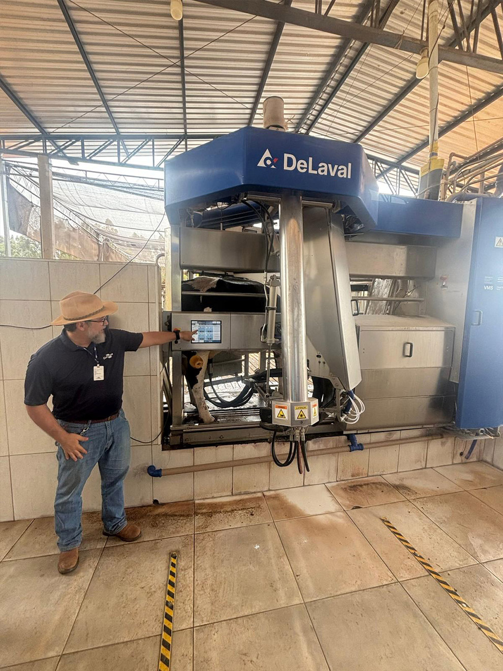 Pesquisador explica o funcionamento da máquina de tirar leite (ordena automática), na Embrapa Pecuária
