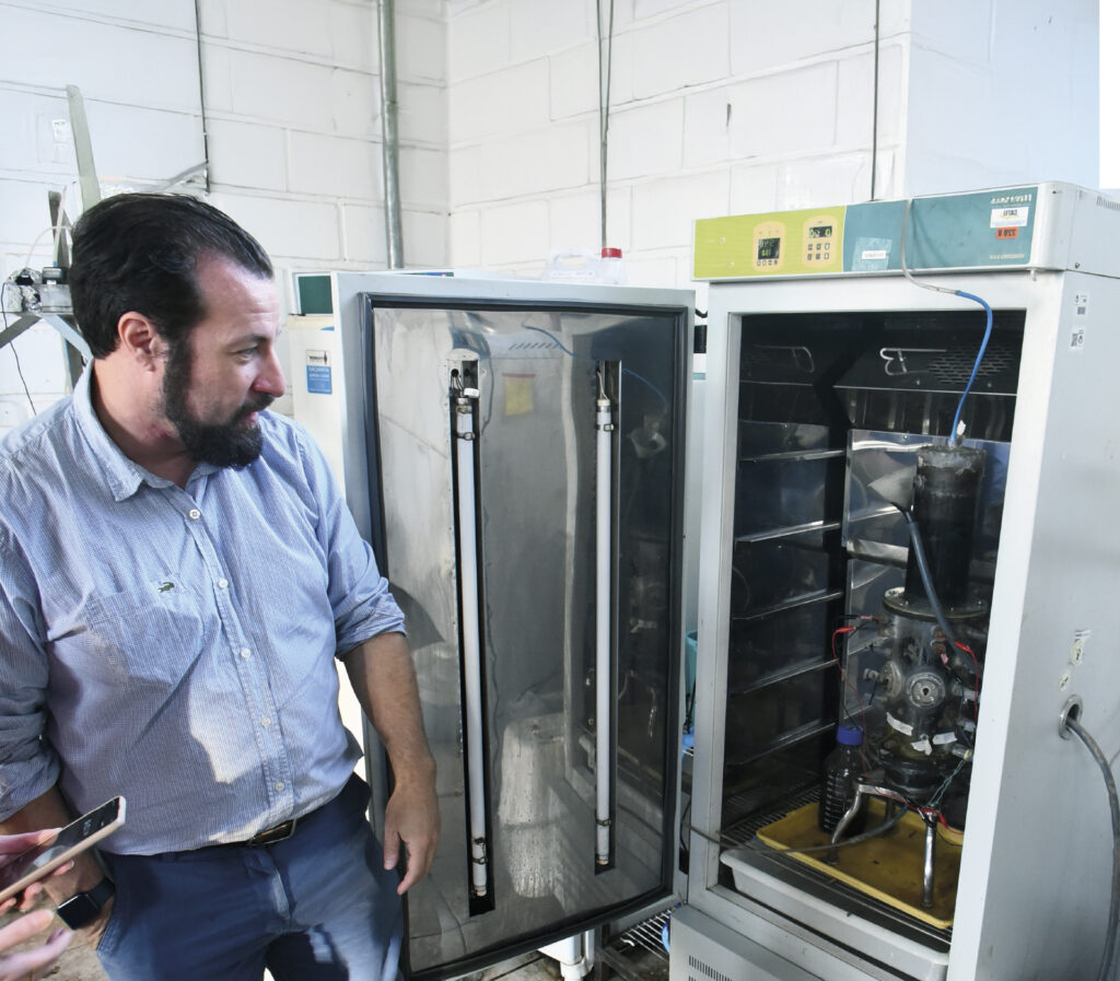 Orientador da pesquisa em frente a equipamento usado no estudo
