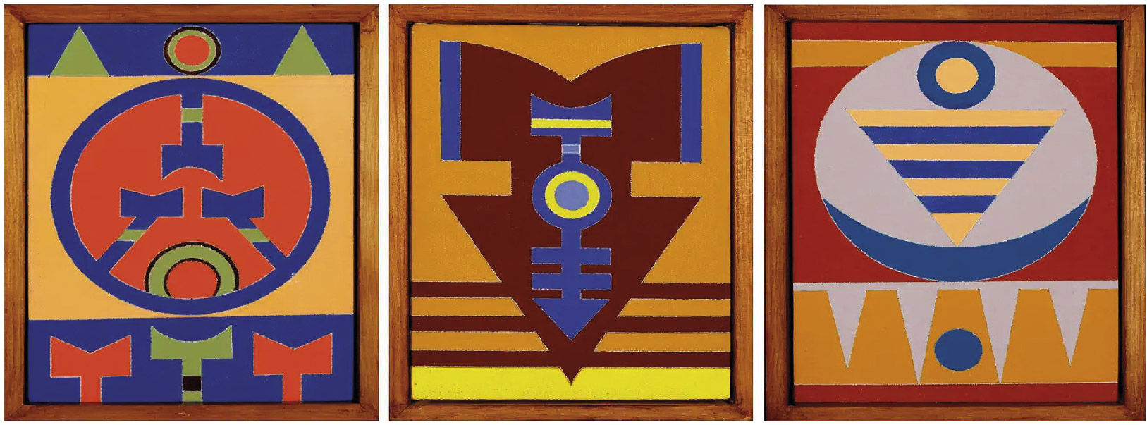 Esta imagem apresenta três pinturas dispostas lado a lado, cada uma em uma moldura de madeira. As obras compartilham um estilo de arte abstrata e geométrica, com forte simetria e o uso de cores vibrantes e terrosas, como azul, vermelho, ocre e marrom. As composições são formadas por formas ousadas e bem definidas — como círculos, triângulos e listras — que se organizam de maneira a criar figuras que lembram totens ou símbolos. Embora cada pintura tenha um arranjo único de formas, elas formam um conjunto coeso e harmonioso.