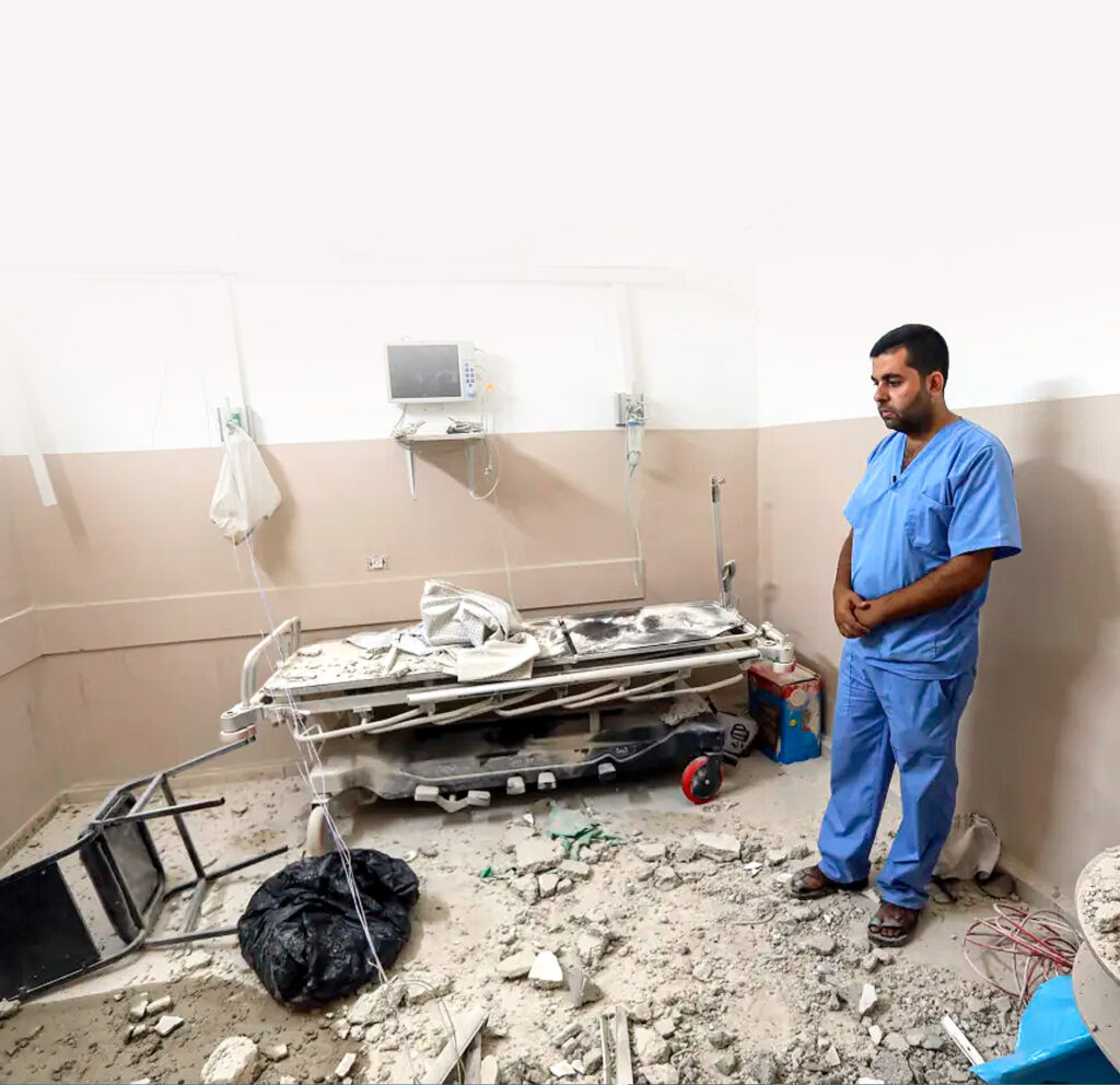 Imagem mostra um médico diante de um quarto de hospital destruído