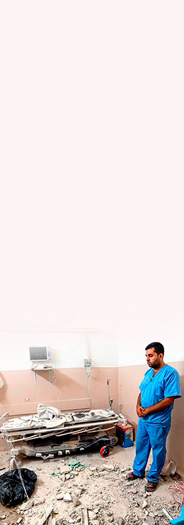 Imagem mostra um médico diante de um quarto de hospital destruído